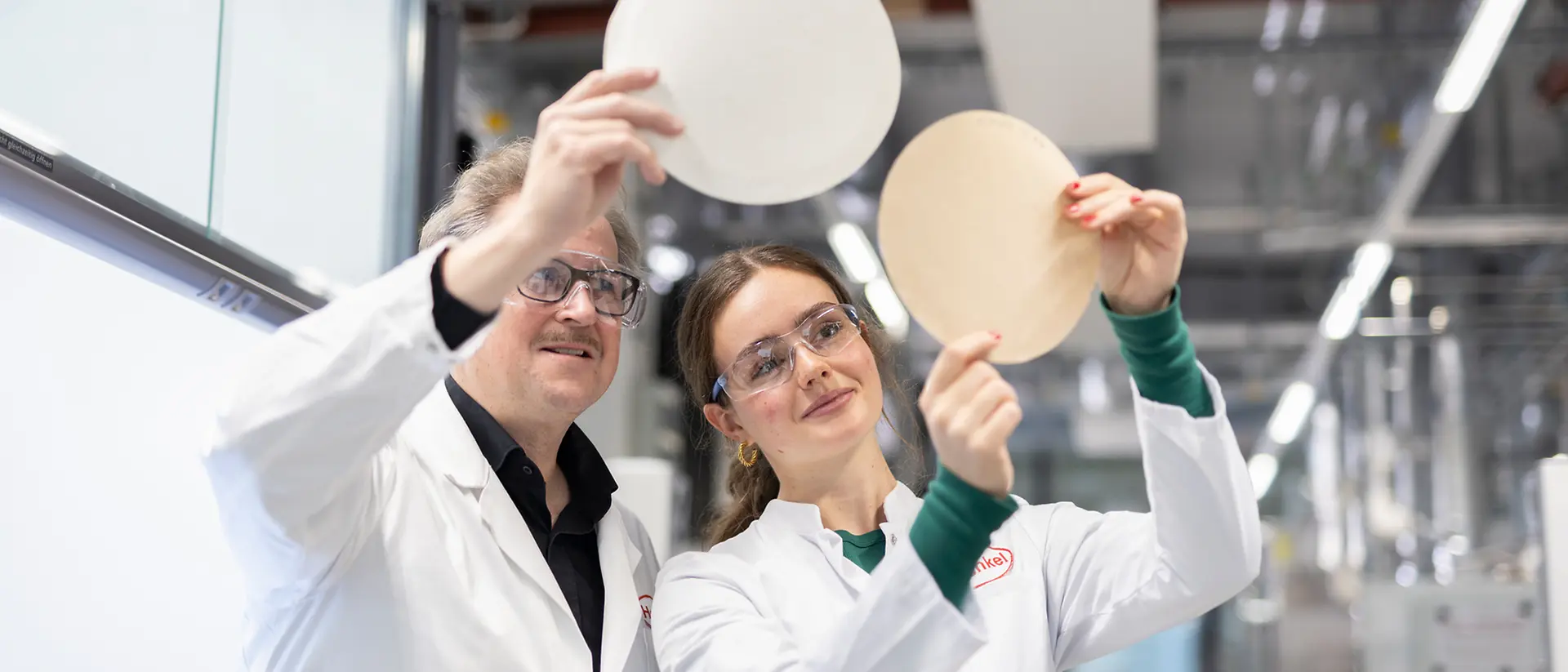 Two people in a lab comparing testing results of the paper recyclability