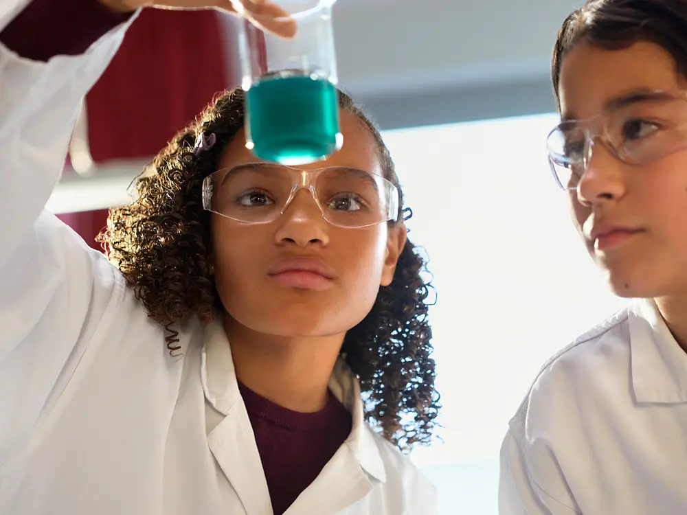 Two children conducting a science experiment in a lab setting.